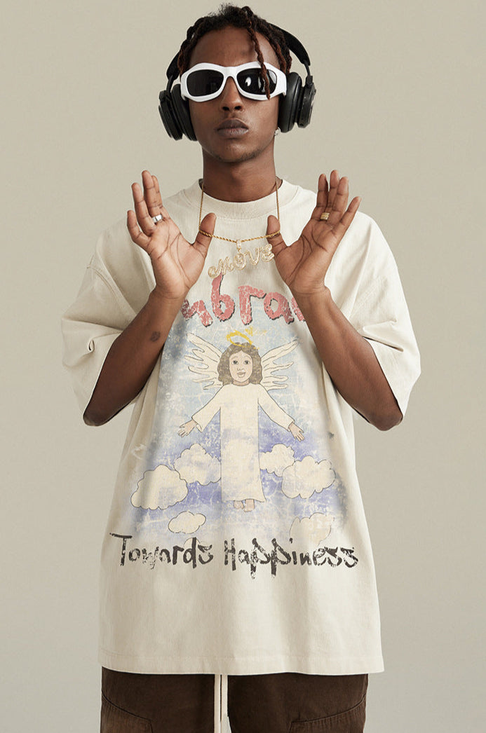 Man wearing cream apricot angel graphic tee with headphones and sunglasses