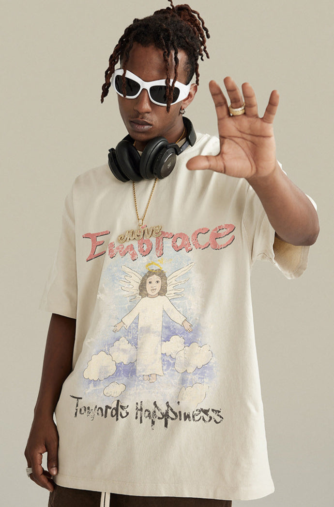 Man in angel tee poses with hands raised wearing headphones and chain