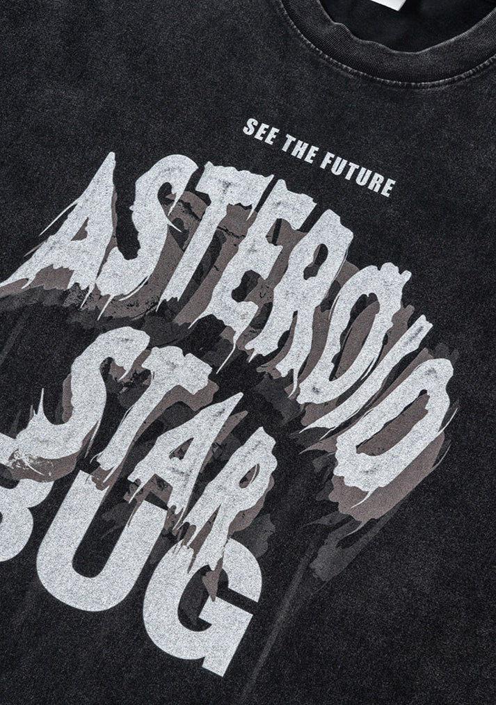 Angled close-up of graphic text on washed black tee.