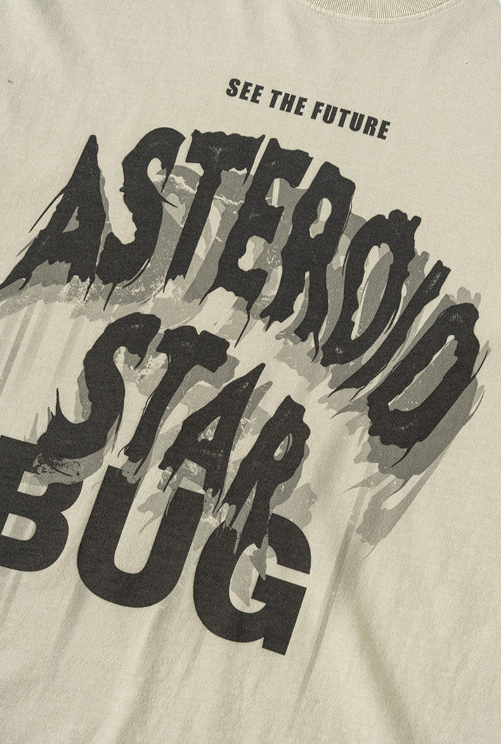Flat lay of cream tee with distressed “Asteroid Star Bug” graphic in black.