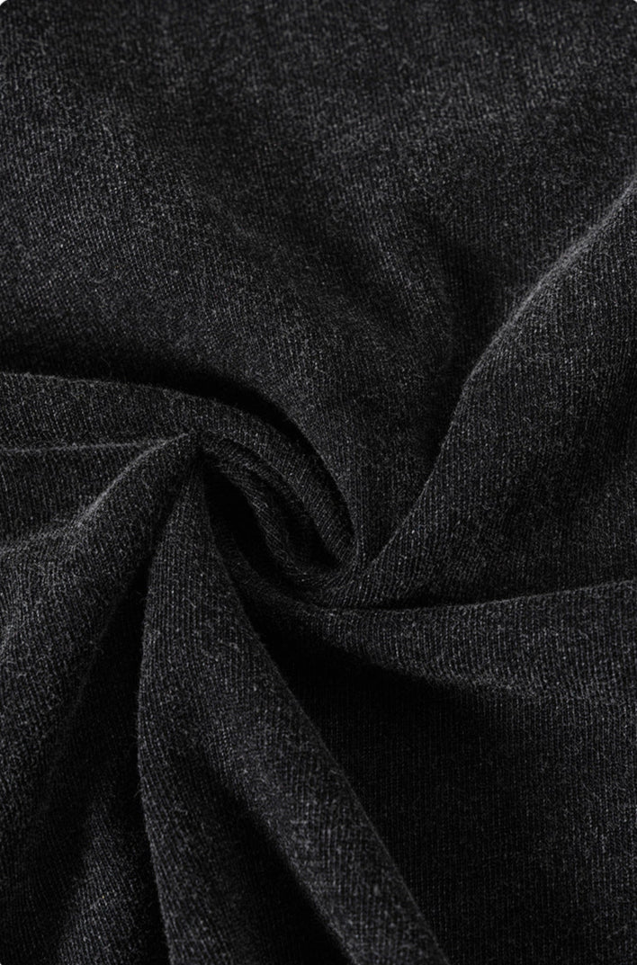 Twisted black tee fabric close-up showing soft cotton texture.