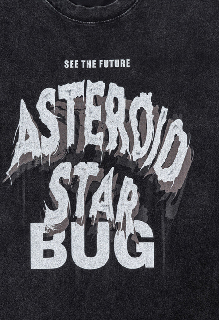 Flat lay of black tee showing bold “Asteroid Star Bug” graphic with distressed style.