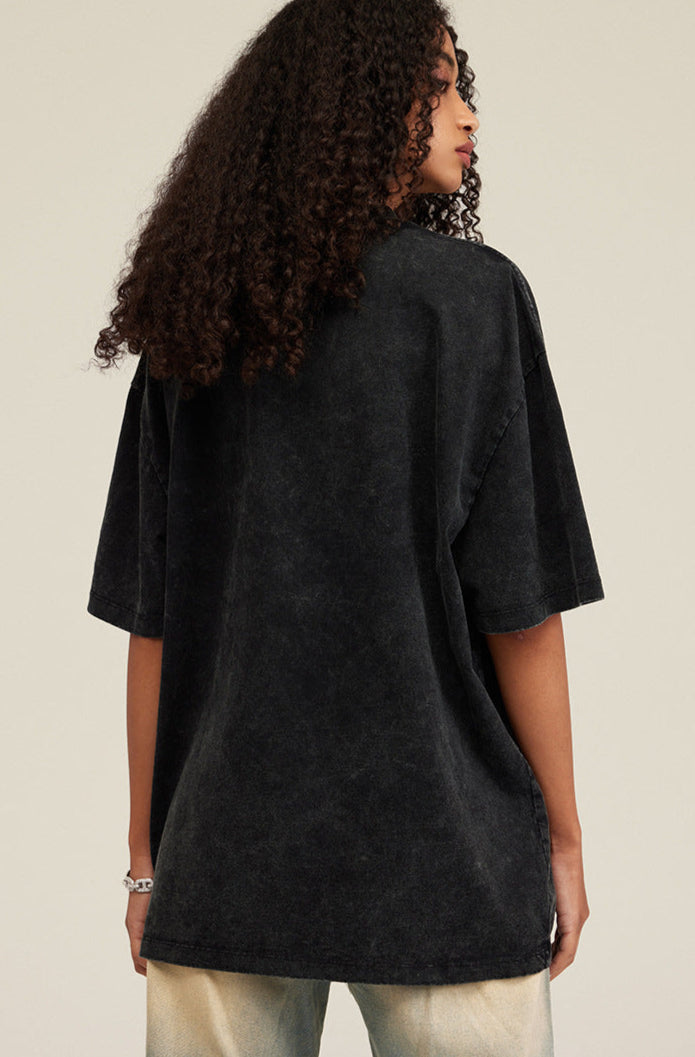 Woman facing away in oversized black washed tee with soft vintage finish.