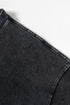 Shoulder seam detail on washed black tee against white background.