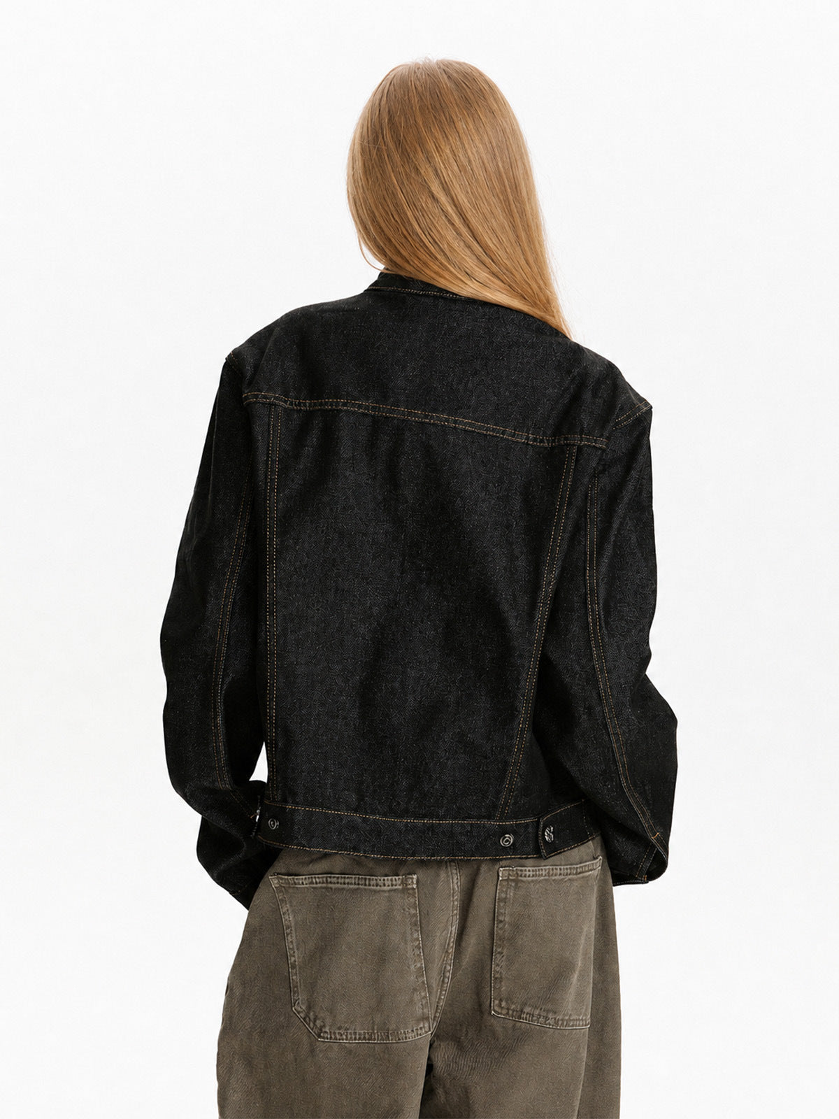 Back view of black short jacket showing panel seams and a straight cropped hem.