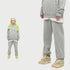 Woman with neon green braids in gray hoodie tracksuit. Close-up shows elastic cuffs and tan Air Jordan sneakers