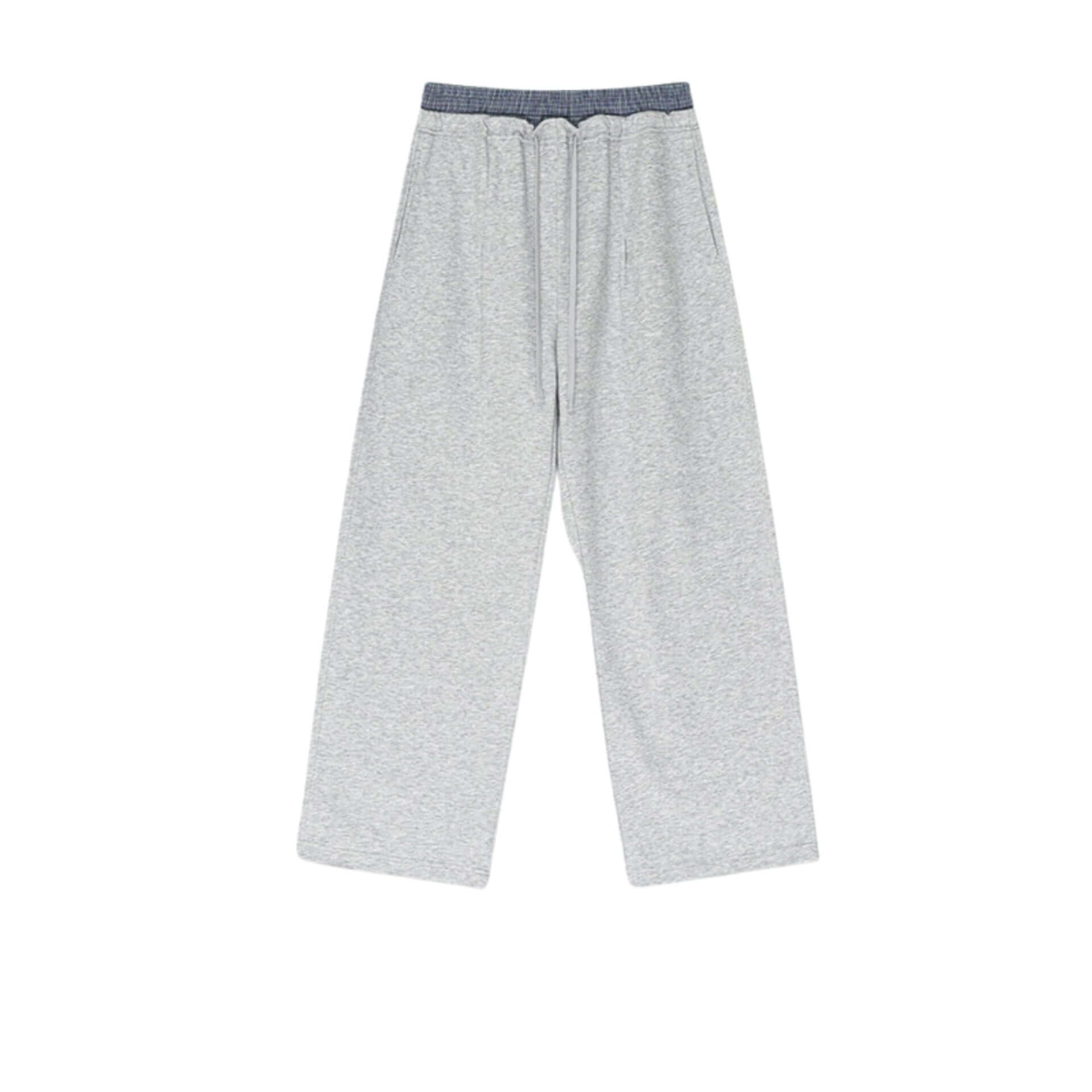 Gray wide-leg sweatpants with an elastic waistband and drawstring, laid flat on a neutral textured surface.