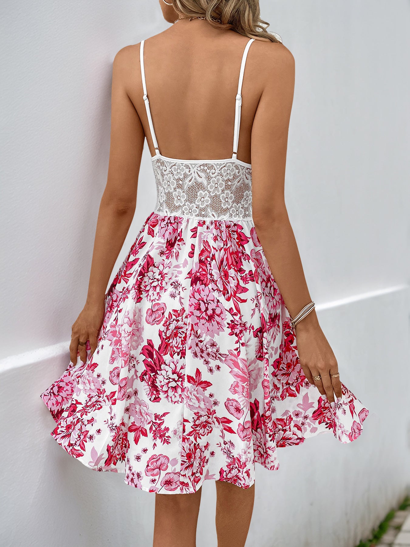 Back view of white floral sundress with lace panel and adjustable straps.