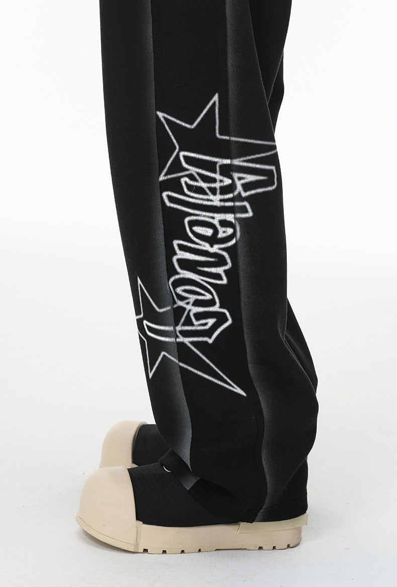 Close-up—star and “Lonely” leg print on black streetwear sweatpants.