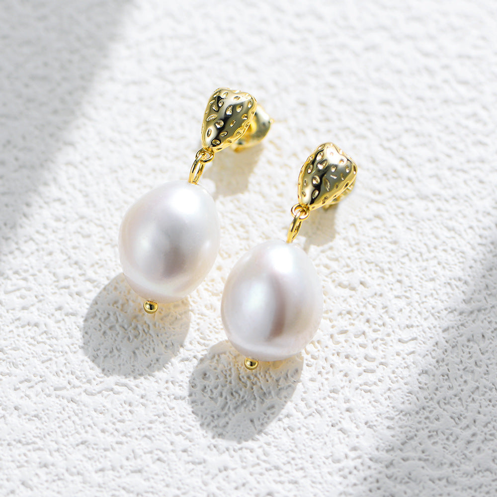 Close-up of baroque pearl drops and textured nugget stud detail