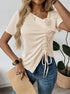 Woman wearing beige ruched top with 3D flower and jeans