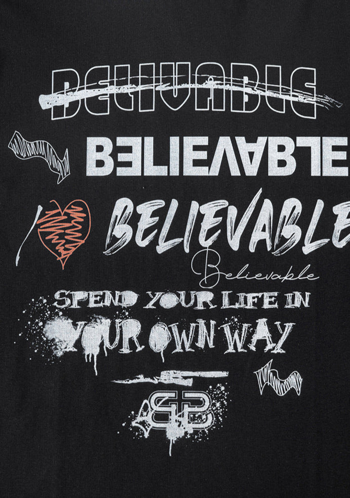 Close-up of full graphic print on black T-shirt featuring layered 'Believable' typography and slogans.