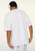 Back view of white oversized T-shirt worn by model.