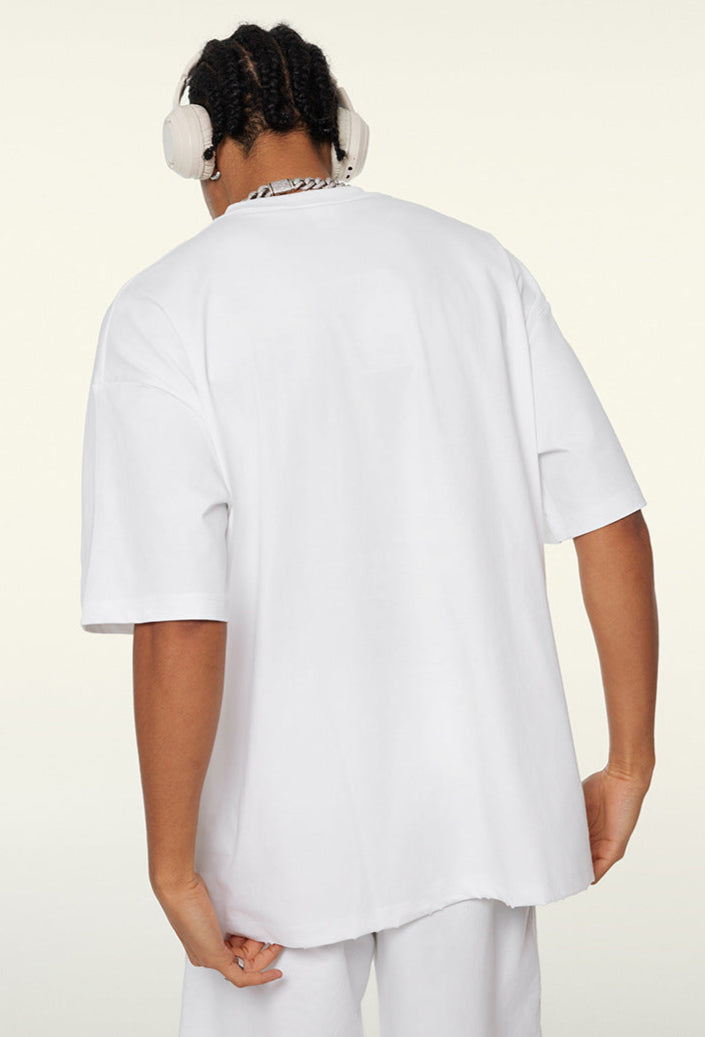 Back view of white oversized T-shirt worn by model.