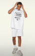 Model wearing white oversized graphic tee and shorts, looking down while adjusting headphones.