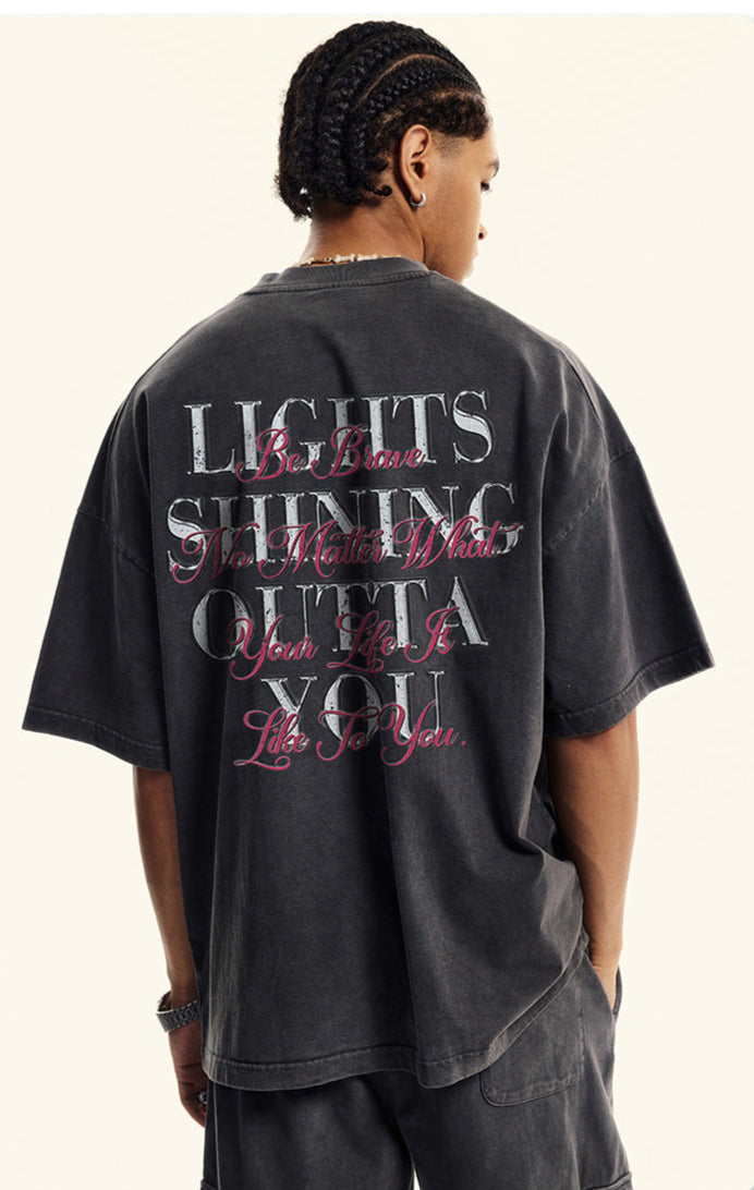 Model showing rear view of black T-shirt with inspirational slogan in mixed fonts.