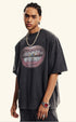 Side view of close-up of black T-shirt featuring detailed grillz illustration and bold lips.