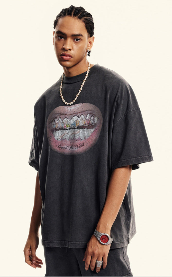 Side view of close-up of black T-shirt featuring detailed grillz illustration and bold lips.