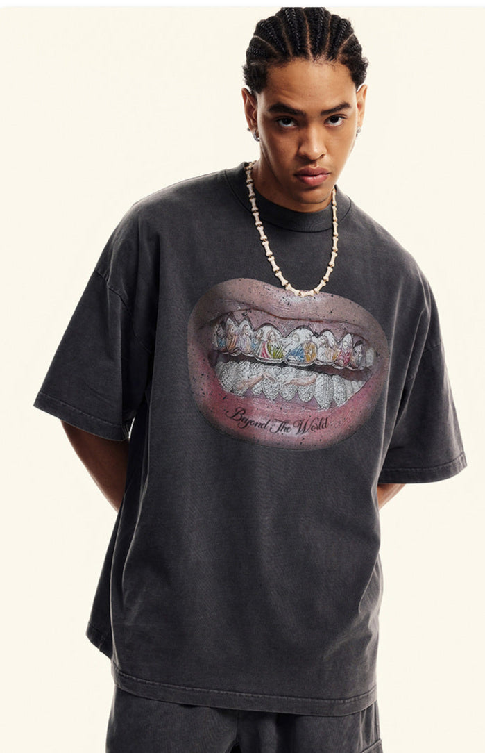 Close-up of black T-shirt featuring detailed grillz illustration and bold lips.