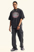 Model standing in black oversized T-shirt featuring surreal open-mouth grill design