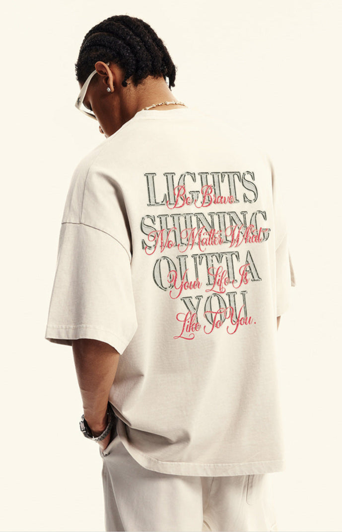 Back view of model wearing off-white graphic tee with inspirational text in red and black.