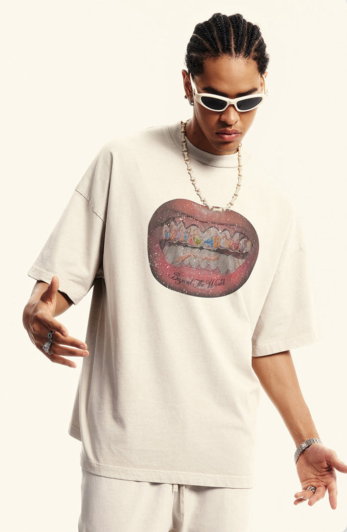 Close-up of off-white T-shirt featuring detailed grillz illustration and bold lips.