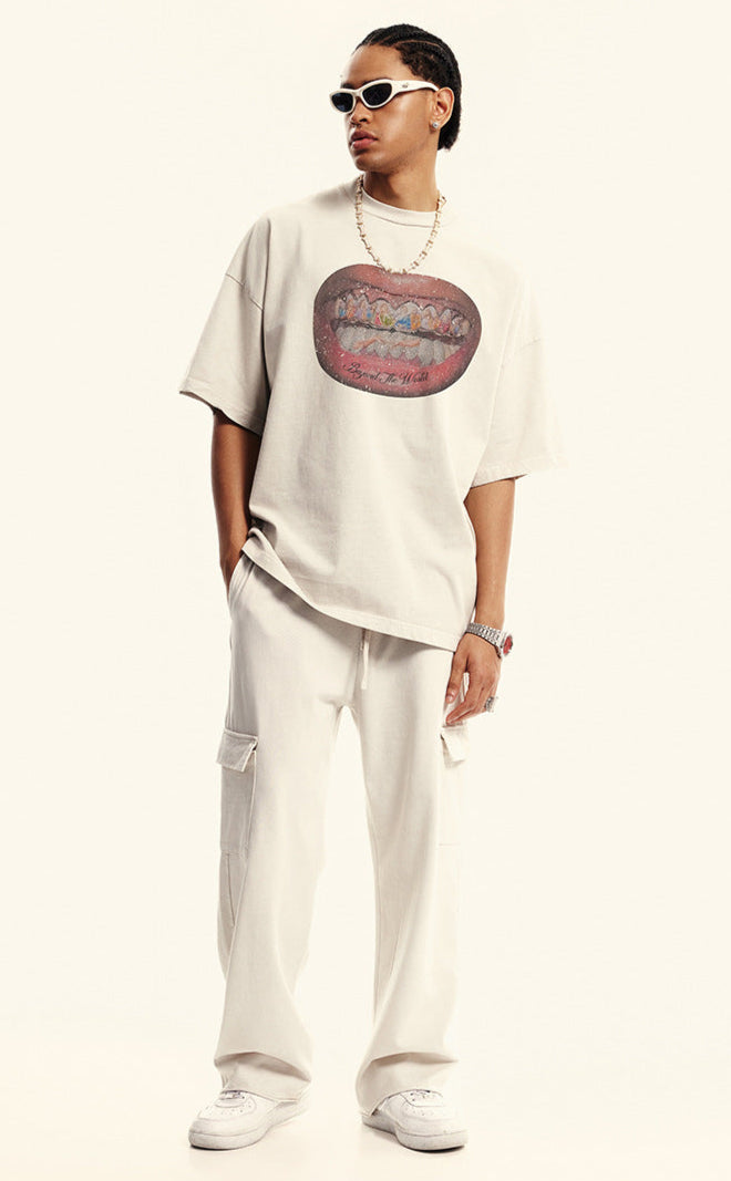 Model wearing off-white graphic T-shirt and matching cargo pants with 'Beyond the World' mouth design.