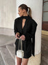 Side view of black blazer paired with mini skirt outfit
