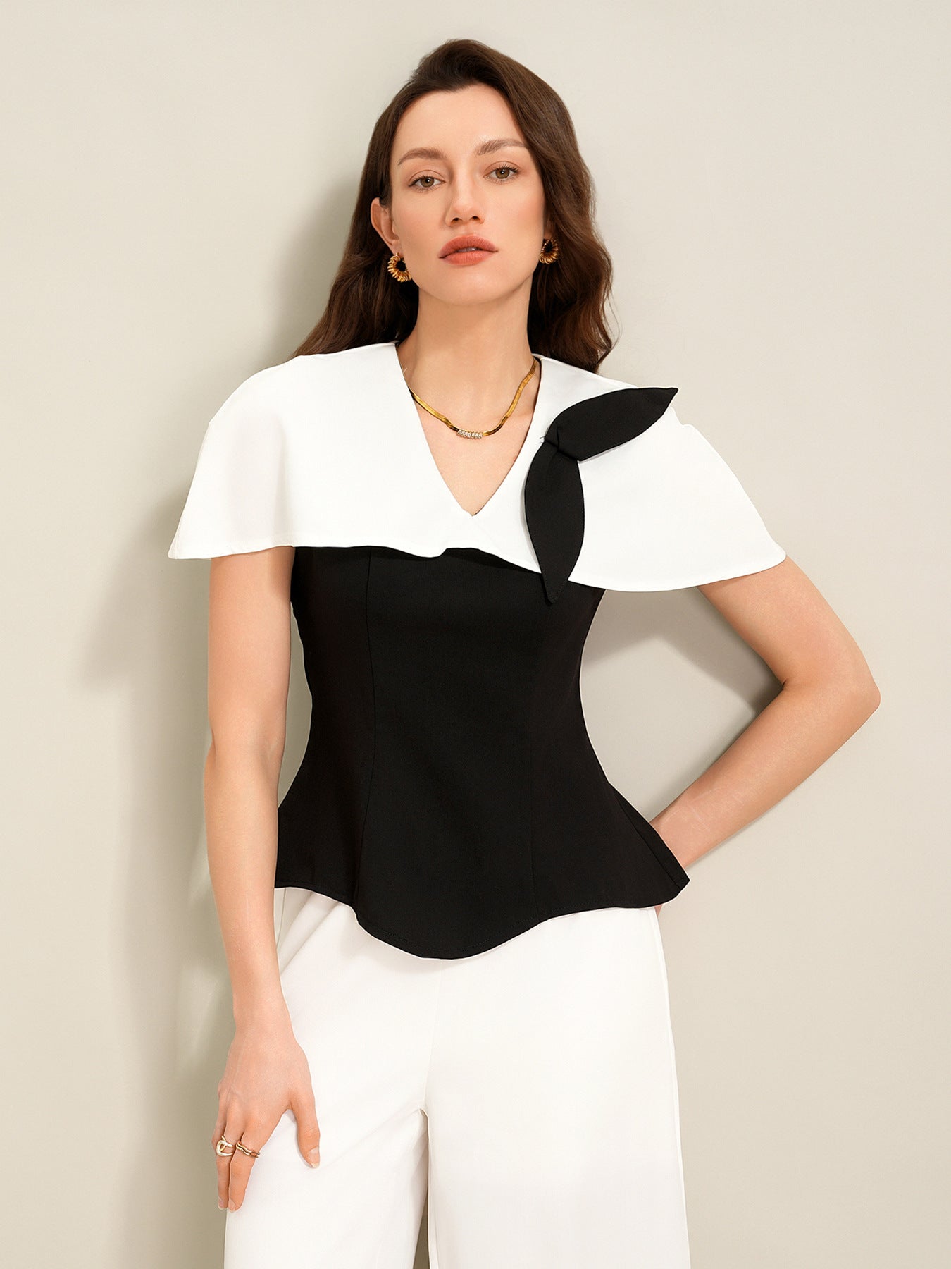 upper body view of black cape top with white collar detail