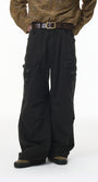 Person wearing black cargo pants and a patterned shirt on a white background