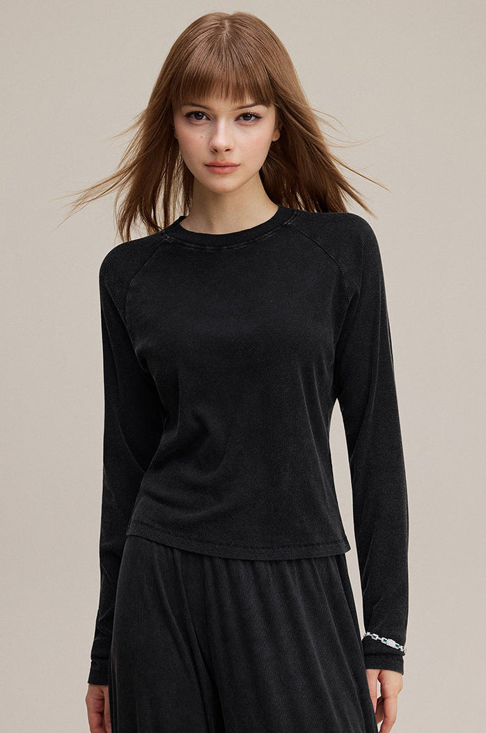 Model wearing black long sleeve tee with slim raglan fit front view