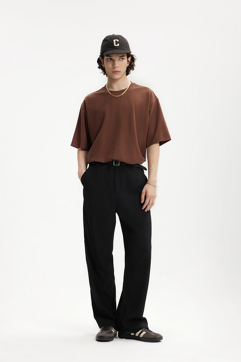 Model in black mens dress pants with brown oversized T-shirt
