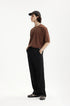 Side profile of black mens dress pants with brown T-shirt outfit