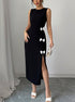 Woman wearing a black slit dress with white bow details against a gray background