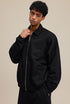 Model in black collared zip sweatshirt, close side view. 