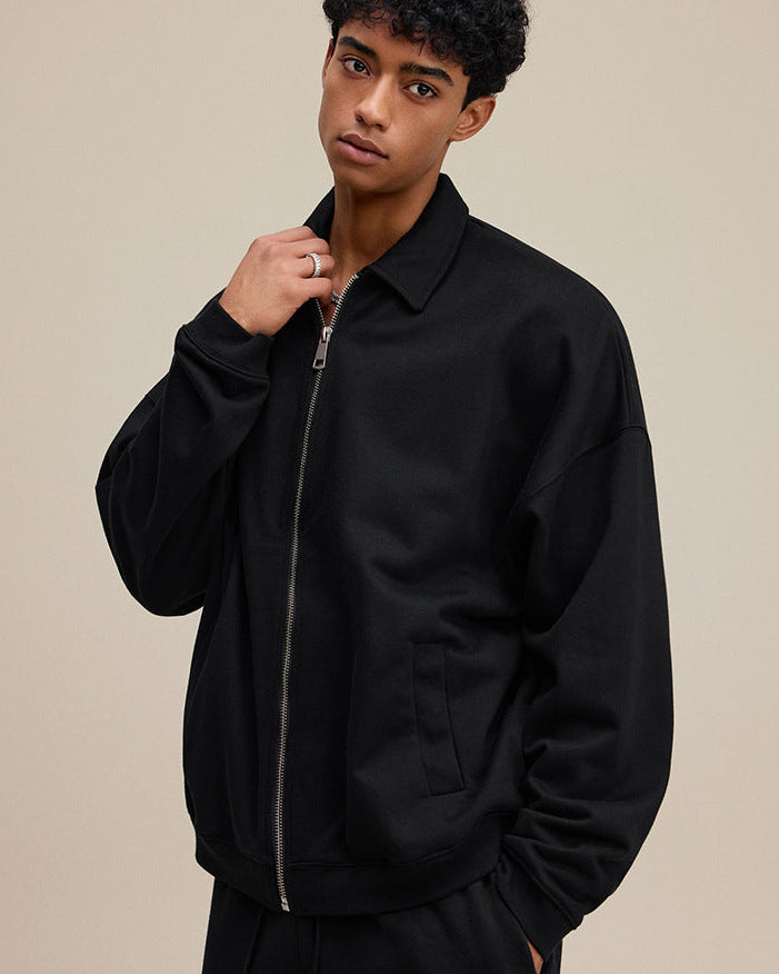 Model in black collared zip sweatshirt, close side view. 