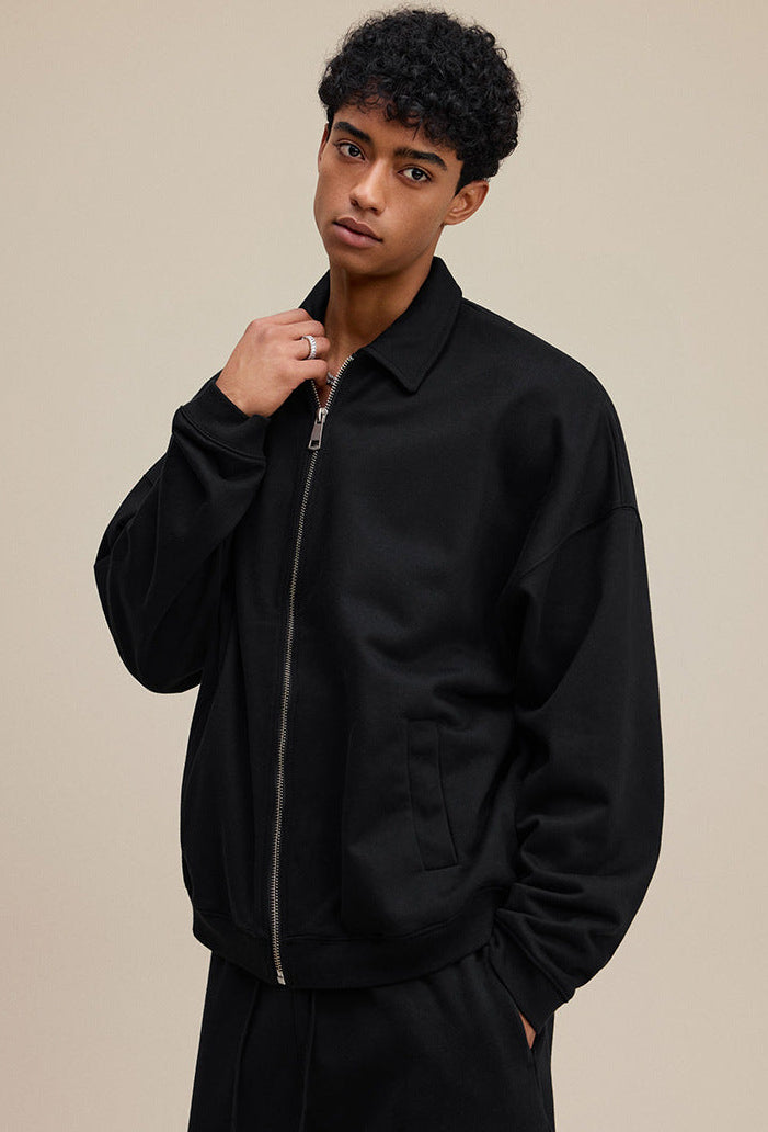 Model in black collared zip sweatshirt, close side view. 