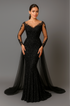 Woman wearing black evening gown with sheer sleeves against a gray background