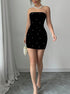 Black strapless bodycon mini dress with pearl details shown in full-length standing view.