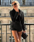 woman wearing black suede jacket with fur collar on balcony