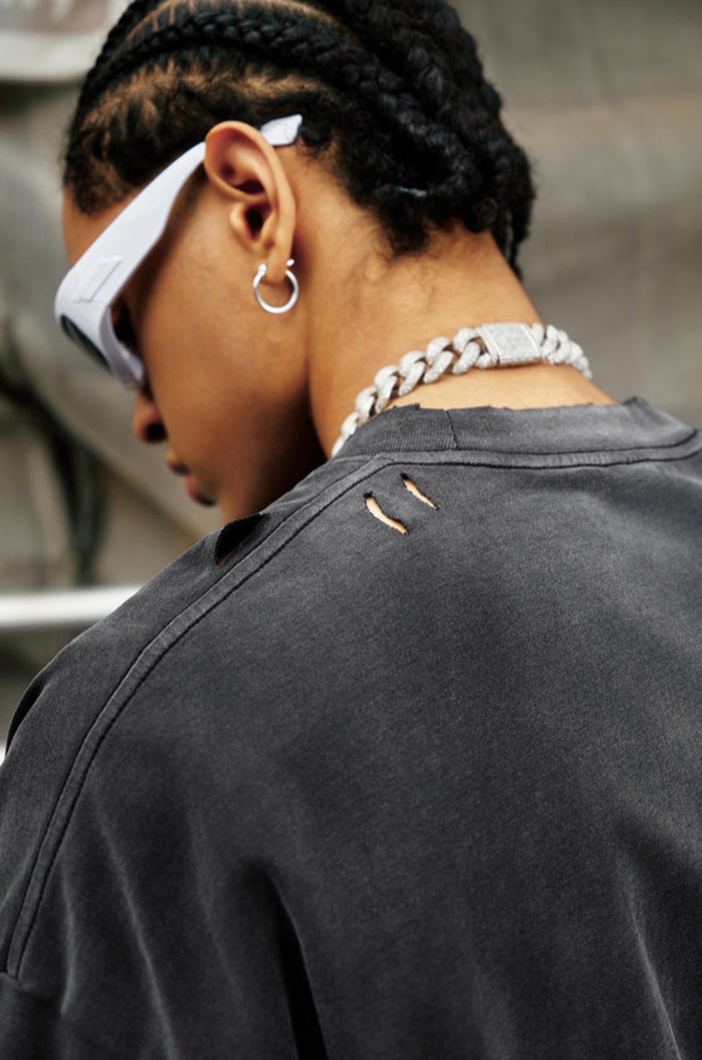 Close-up of distressed shoulder detail on black quote tee, paired with silver chain and sunglasses.
