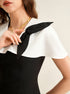 close-up of black and white cape collar detail on top