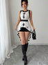 Woman wearing black & white sleeveless embroidered peplum top with high-low hem and boots