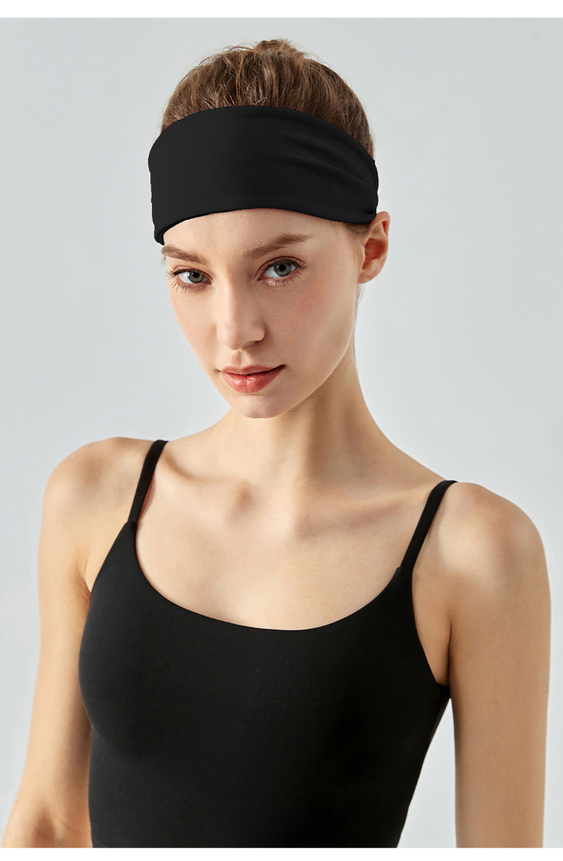 Front view of woman wearing black workout headband.