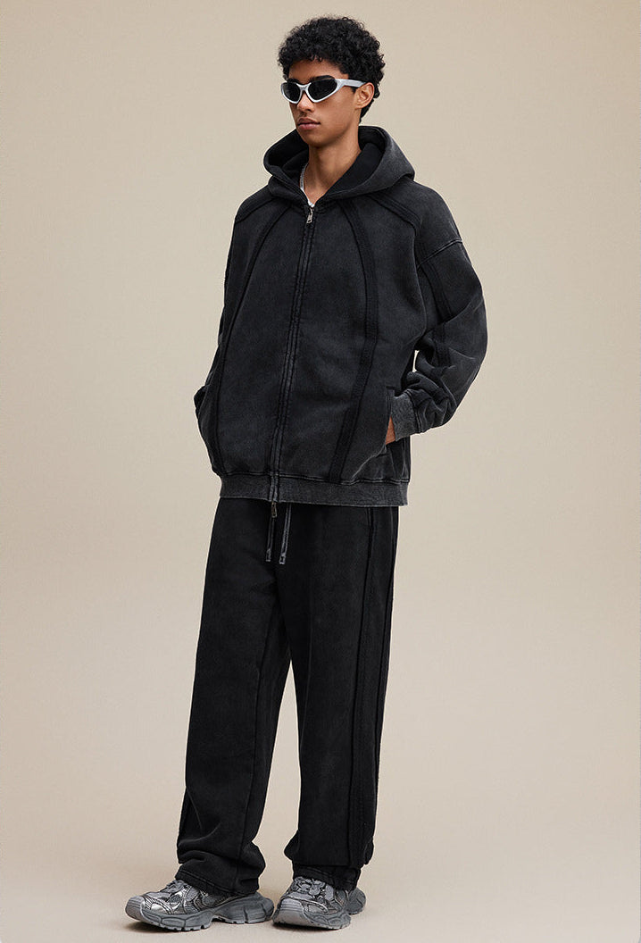 Model full outfit in black zip hoodie and pants, oversized fit, side view. 