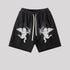 Black cotton shorts featuring white embroidered cupid angels and drawstring waist on light gray background