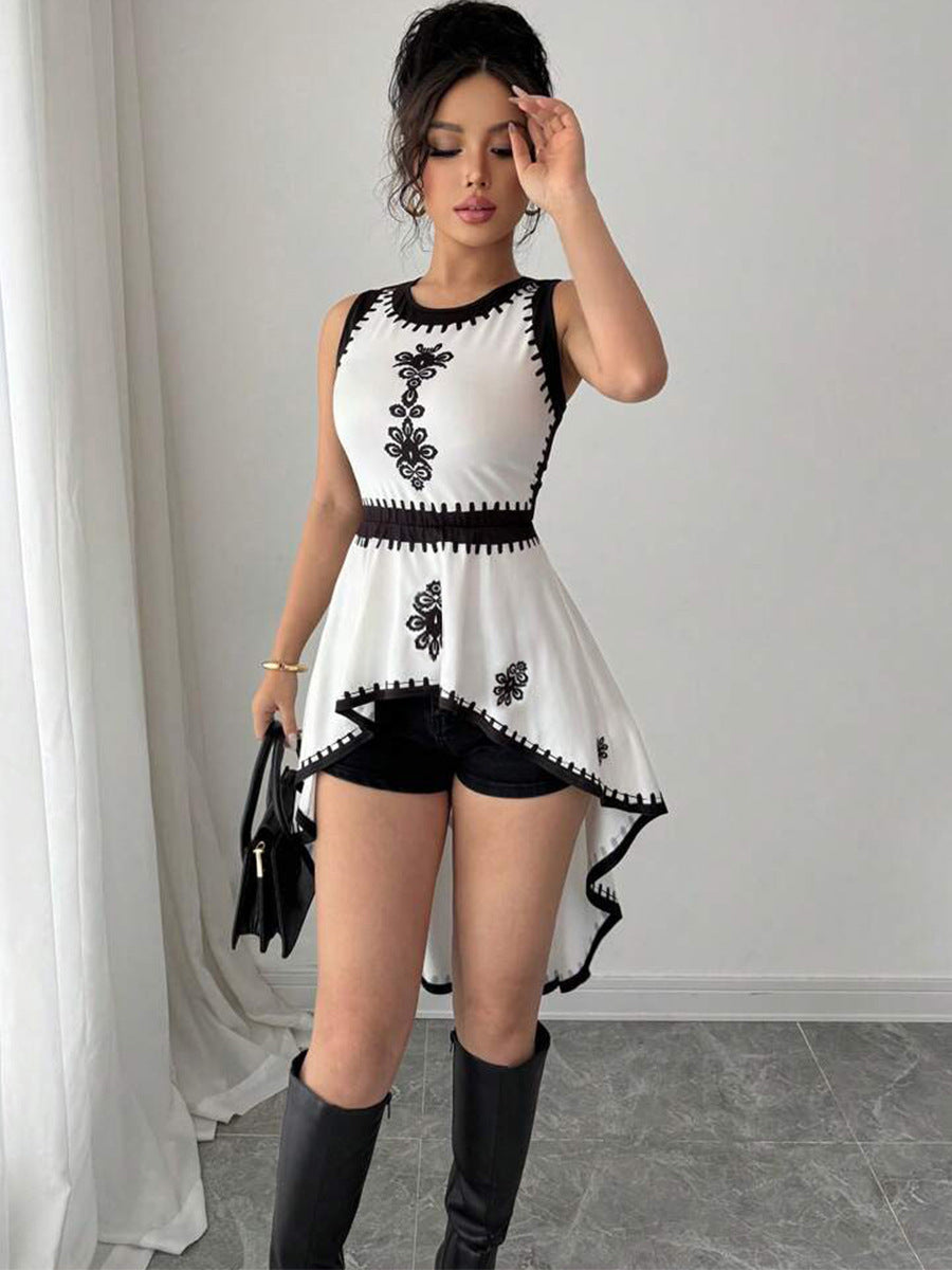Woman wearing sleeveless embroidered peplum top with high-low hem and boots
