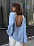 Back view of woman in light blue backless knit sweater