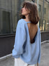 Woman wearing light blue backless knit sweater outdoors