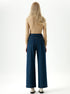 Back view of high rise straight leg denim jeans styled with neutral top.